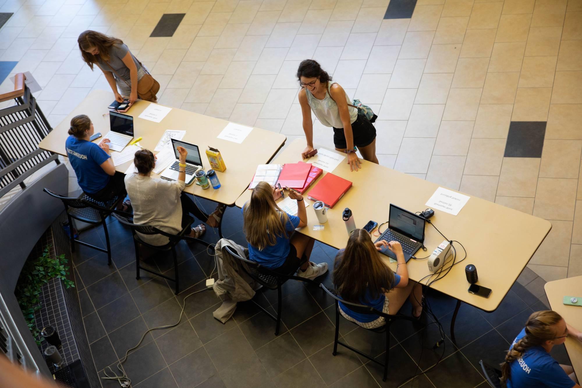 students at a table asking for information